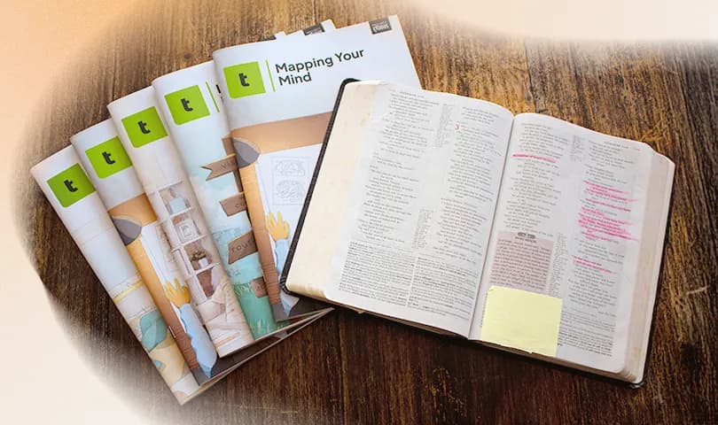 An open Bible lies next to ‘Thrive’ workbooks.
