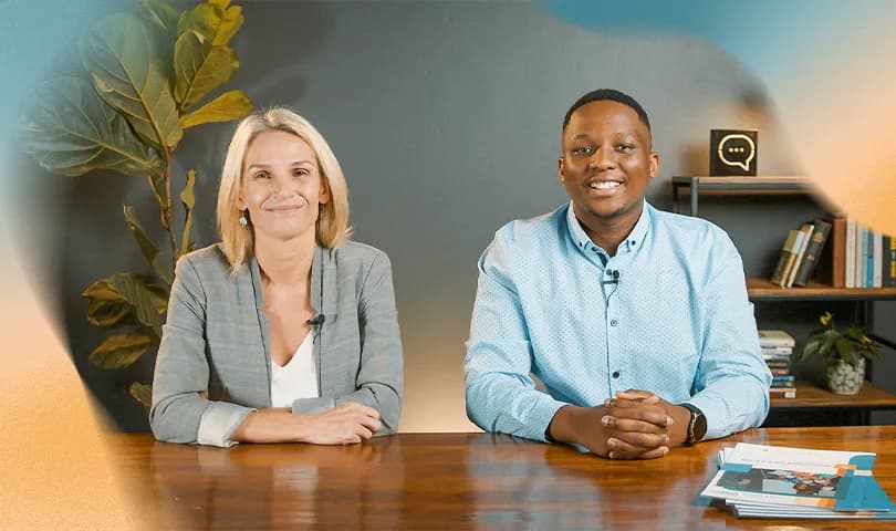 Man and woman at a desk engaged in online facilitator training.